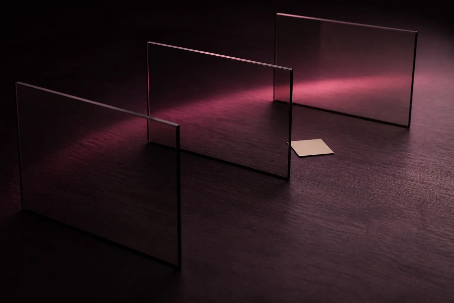 Three smoked-glass panels receding across a plum desk toward a small cream paper square.
